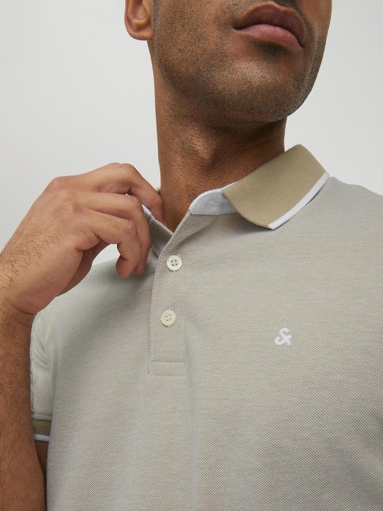 Lichtgrijs poloshirt met beige kraag en witte bies, close-up van de halslijn.