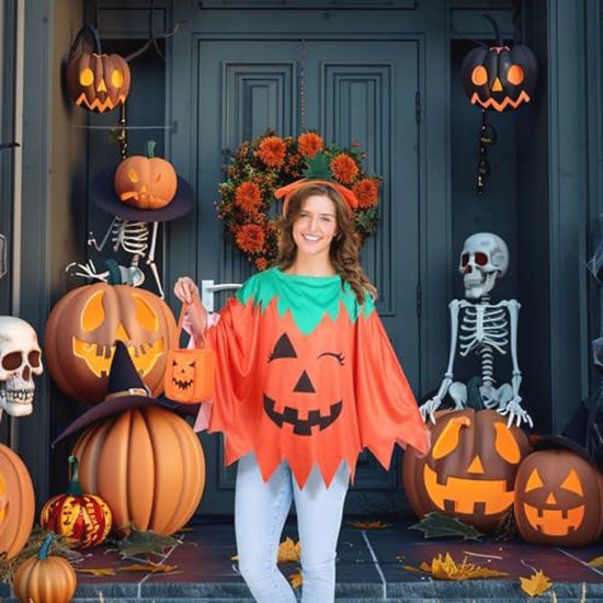 Vrouw in pompoenkostuum voor een deur met pompoenen, schedels en Halloween-decoratie.