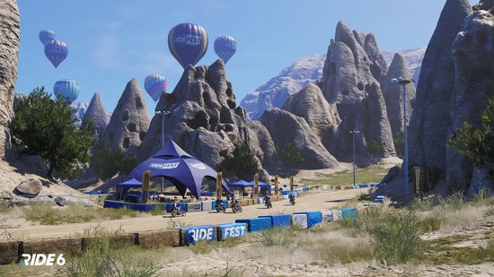 Festivalterrein met tenten, bergen en luchtballonnen met 'RIDE FEST'.