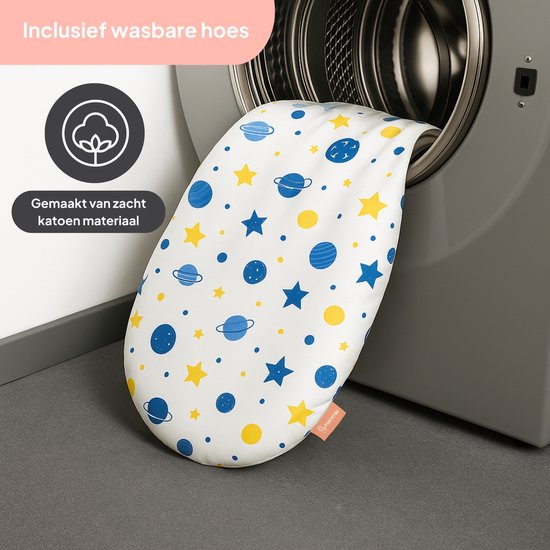Wit wasbaar kussen met print van blauwe planeten, gele sterren en stippen. Ligt in een wasmachine. "Inclusief wasbare hoes. Gemaakt van zacht katoen"