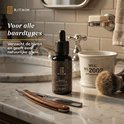 Fles baardolie op een marmeren aanrecht, naast een scheermes, scheerkwast en mok. Tekst: "Voor alle baardtypes".