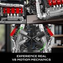 Gedetailleerde LEGO Technic V8 motor met bewegende zuigers, rode cilinders en chromen uitlaten.