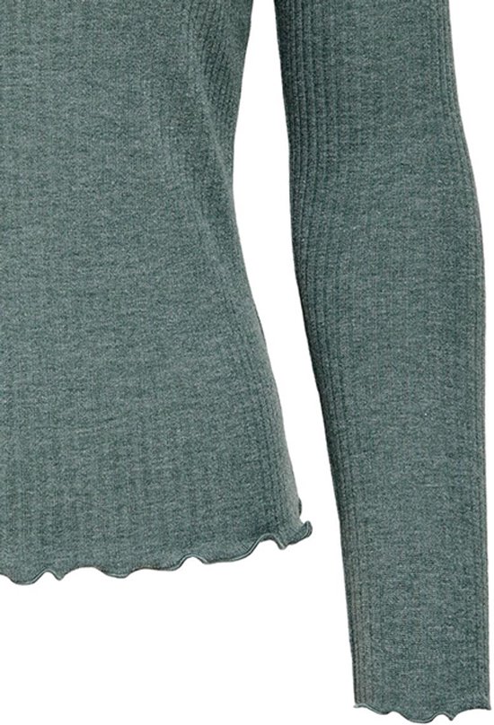Detail van de effen groene top met geribbelde stof, lange mouwen en ruches aan de zoom.