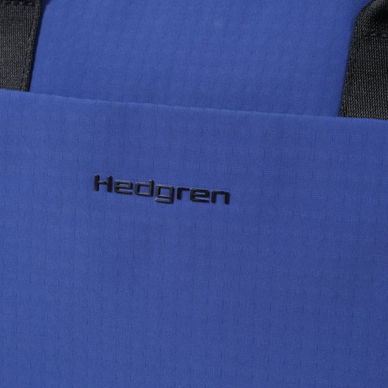 Detail van het Hedgren logo op een blauwe rugzak.