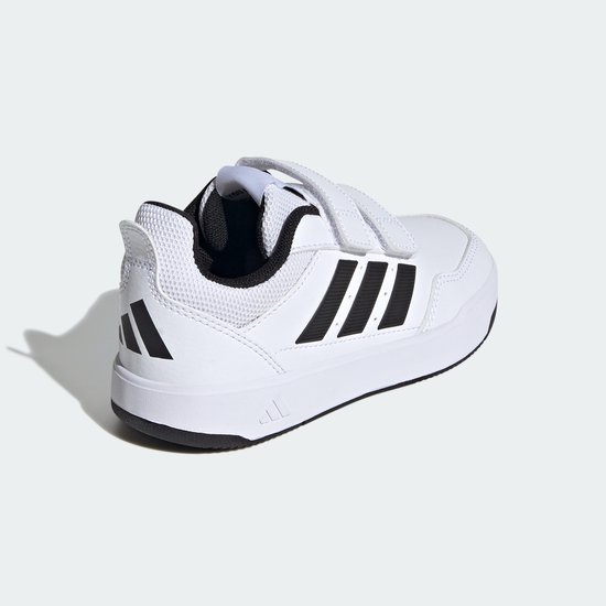 Witte Adidas sneaker met klittenbandsluiting, zwarte strepen en een zwarte zool. Vanuit de achterkant gezien met zwarte Adidas logo.
