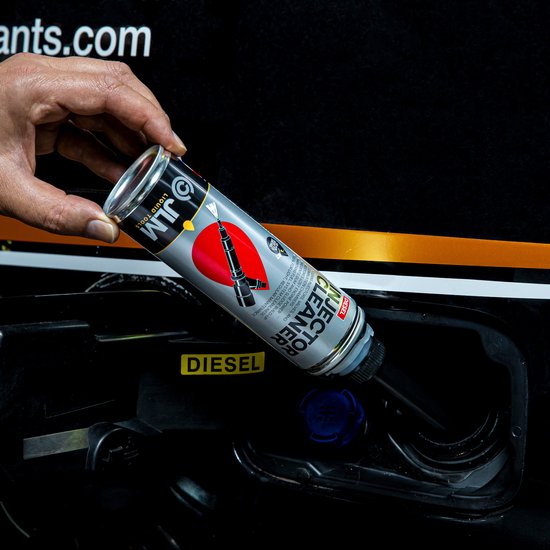 Hand giet JLM Diesel Injector Cleaner in de diesel tank van een auto.