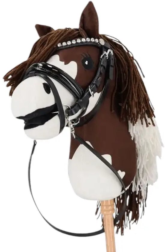 Bruin en wit gevlekt stokpaard met zwarte manen, een bruin hoofdstel en witte versiering aan de staart.