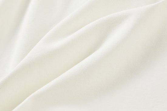 Platliggend off-white katoen van een jurk.