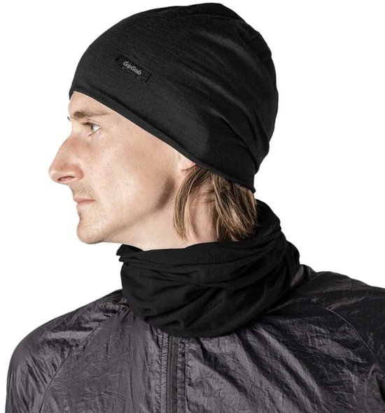 Een man met een zwarte merinowollen muts en nekwarmer van GripGrab, profiel van links. Hij draagt een zwarte jas.