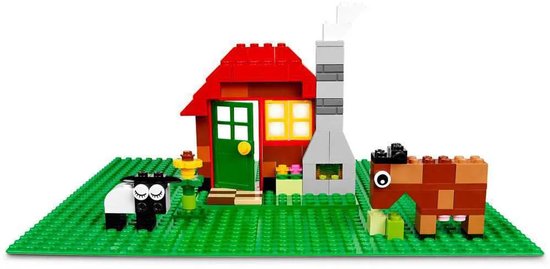 LEGO boerderij met rode huis, schoorsteen, schaap en bruine koe op groene bouwplaat.
