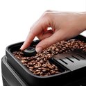 Hand past de maalgraad aan met de draaiknop op de De'Longhi Magnifica EVO.