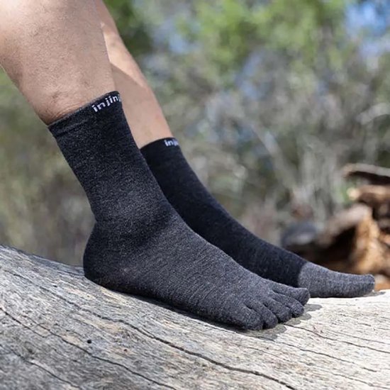 Homme portant des chaussettes doigts de pied Injinji gris foncé dans un environnement forestier.
