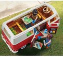 Twee PLAYMOBIL-figuren in een rode en witte camperbus, met accessoires zoals bekers en een kaart.