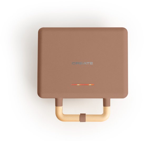 Bruin tosti-ijzer met 'CREATE' logo en oranje indicatorlampje. Houten handvat aan de onderkant.