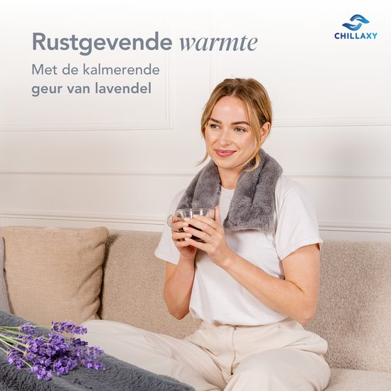 Vrouw met grijze pittenzak om haar nek, genietend van een kopje thee.