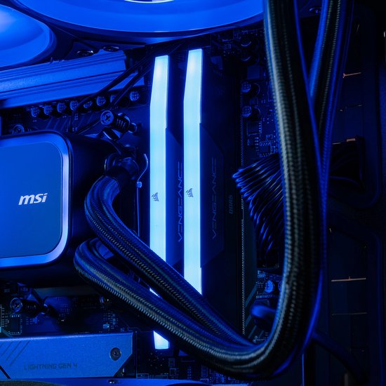 Close-up van de binnenkant van een gaming pc met blauw verlicht RAM-geheugen en een waterkoelingsysteem met zwarte slangen.