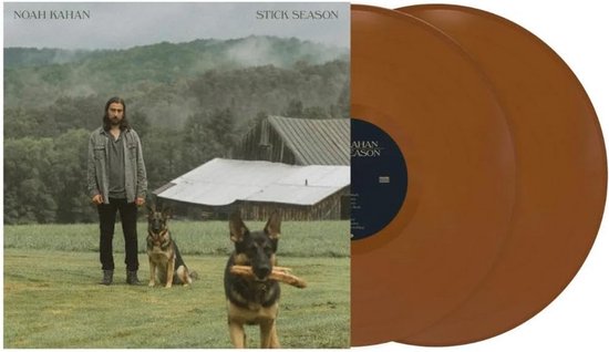 Noah Kahan 'Stick Season' albumhoes met een man, twee honden en een schuur op het platteland. Naast de hoes liggen twee bruine vinylplaten.