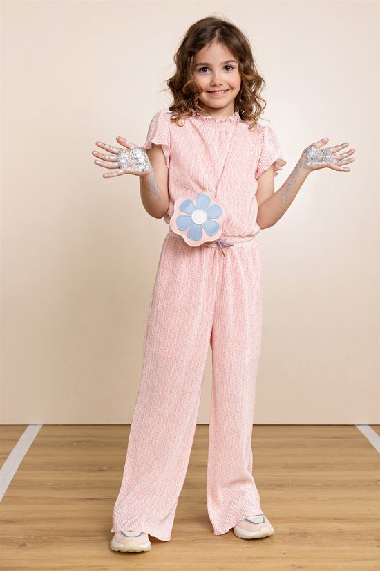 Meisje met lang krullend haar draagt een roze jumpsuit met glitterdetails, strikceintuur en een lichtblauwe bloemtas.