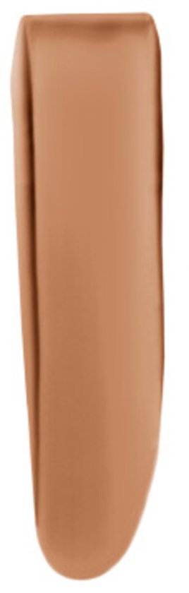 Een swathe van lichte tot medium bruine foundation op een witte achtergrond.