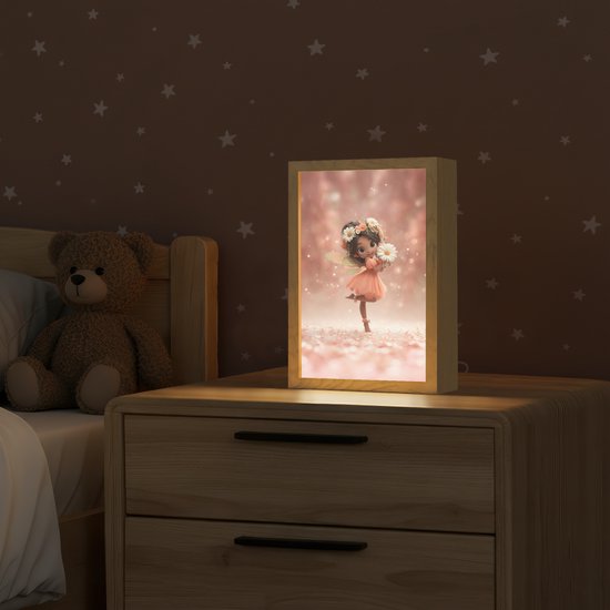 Houten lamp met een fee met bloemenkrans en jurk, die een bloem vasthoudt op een roze achtergrond.