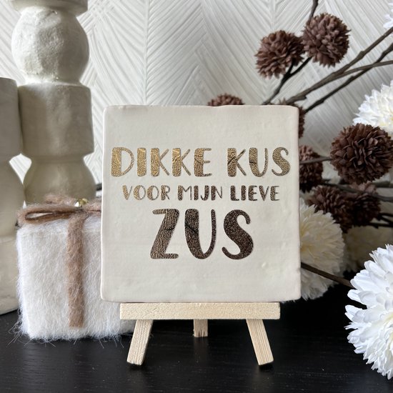 Wit tegeltje met gouden tekst: "DIKKE KUS VOOR MIJN LIEVE ZUS".