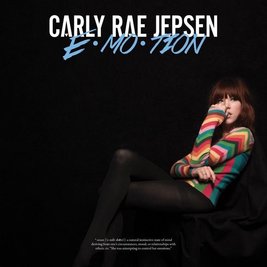 Carly Rae Jepsen draagt een kleurrijke, chevron-gebreide trui en zwarte panty's.