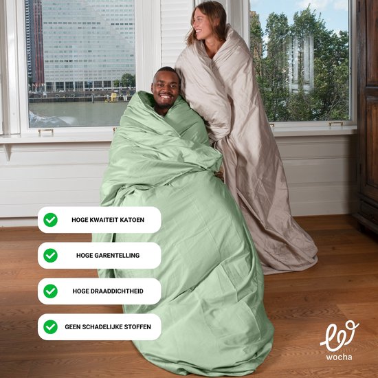 Man en vrouw, omringd door een zacht beige dekbedovertrek, met groene dekbedovertrek op de man. Checkmarks met: 'Hoge kwaliteit katoen', 'Hoge garentelling', 'Hoge draaddichtheid', 'Geen schadelijke stoffen.'