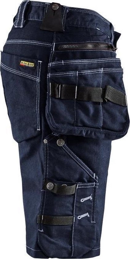 Donkerblauwe werkbroek met veel zijden zakken, ritssluitingen, lussen en wit stiksel.