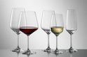 Six verres à vin et flûtes, dont un rempli de vin rouge et un de vin blanc.