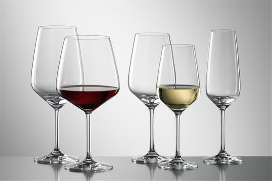 Six verres à vin et flûtes, dont un rempli de vin rouge et un de vin blanc.