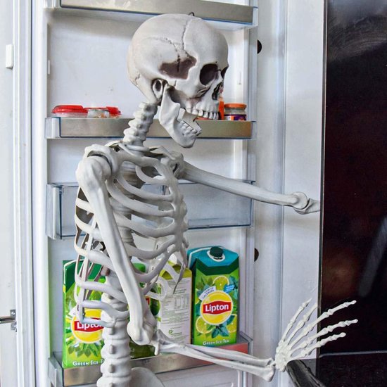 Een levensgroot skelet staat voor een open koelkast met Lipton Ice Tea pakken.