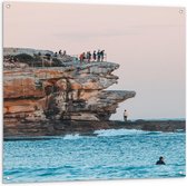 Tuinposter – Mensen op Rots bij Zee - 100x100cm Foto op Tuinposter  (wanddecoratie voor buiten en binnen)