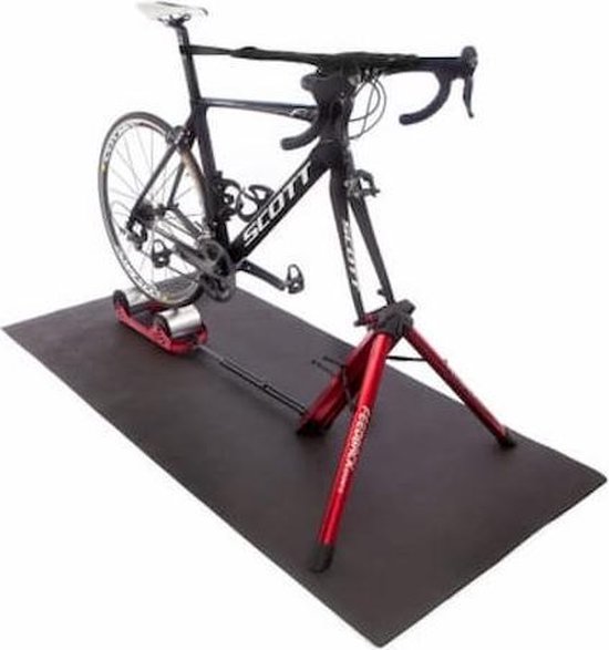 Een Scott racefiets staat op een rode Fietstrainer op een zwarte mat.