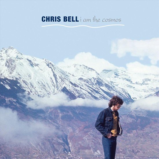 Albumhoes met de tekst "CHRIS BELL i am the cosmos". Een man staat op een berg met besneeuwde bergtoppen op de achtergrond.