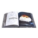 Open kookboek met links slagroom en rechts een pavlova met fruit.