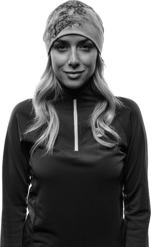 Zwart-wit portret van een vrouw met muts met takkenpatroon en een vest met rits.