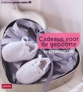 Twee gebreide babyslofjes in een hartvormige geschenkdoos met lint. "Cadeaus voor de geboorte"