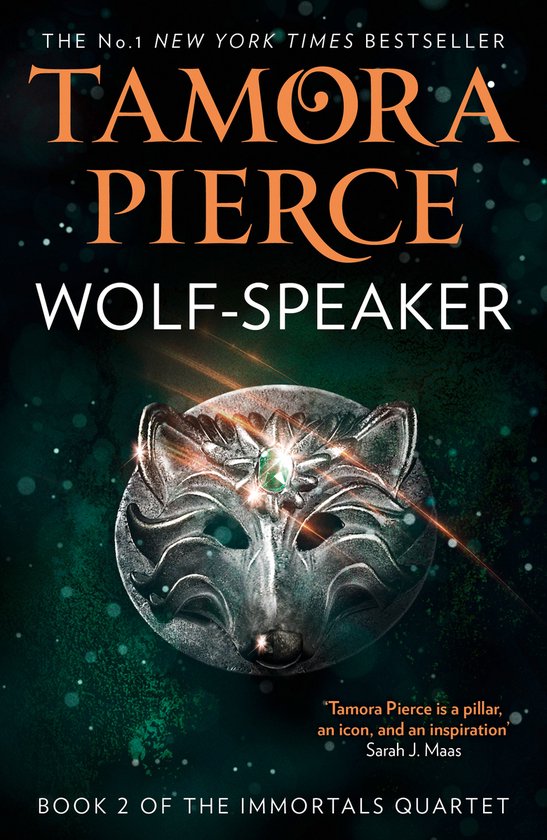 Boekomslag van Wolf-Speaker door Tamora Pierce met een zilveren wolvenmasker met een groene edelsteen op donkergroene achtergrond.