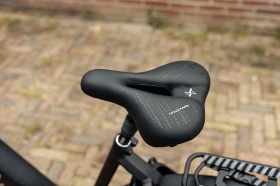Detailopname van een zwart fietszadel met perforaties en het Voltano logo.
