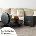 Een rode roos in een glazen stolp, liggend op een plateau naast een 'LA ROSE' geschenkdoos.