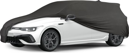 Zwarte autohoes die een witte sportauto met gestileerde velgen bedekt.