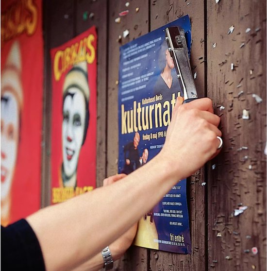 Handen nieten poster op houten muur naast circusposter