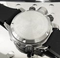 Achterkant van een zilverkleurig Citizen horloge met zwarte band.