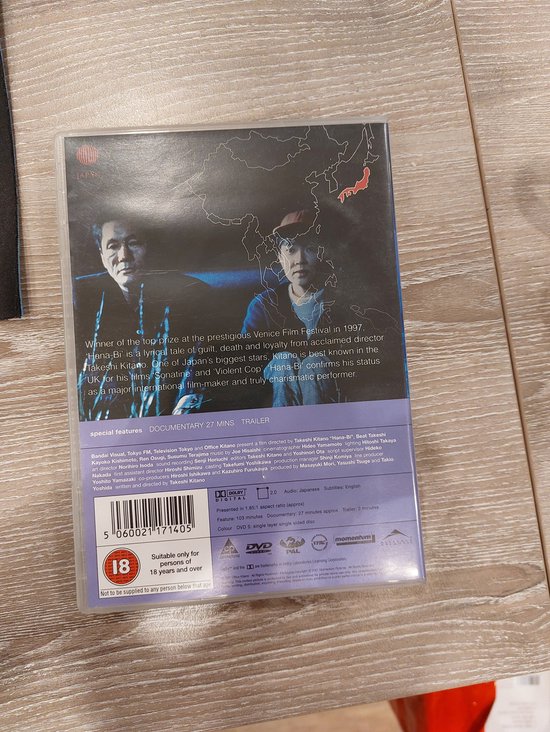 DVD hoes van de film Hana-Bi, met een stillevensfoto van een Japanse kaart en twee mannen.