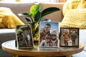 Trois photos encadrées sur une table basse avec une plante.