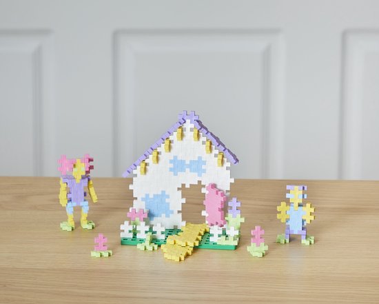 Een Plus-Plus huis met figuren en bloemen, in pastelkleuren.