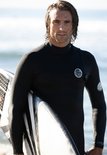 Man in zwart wetsuit met surfplank