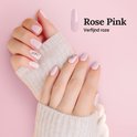 Dameshanden met korte, lichtroze BIAB nagels, versierd met strass. De kleur 'Rose Pink' is verfijnd.