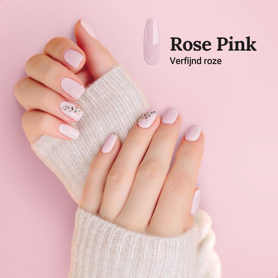 Dameshanden met korte, lichtroze BIAB nagels, versierd met strass. De kleur 'Rose Pink' is verfijnd.