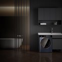 Lave-linge bleu foncé dans une salle de bain moderne avec baignoire et lavabo.